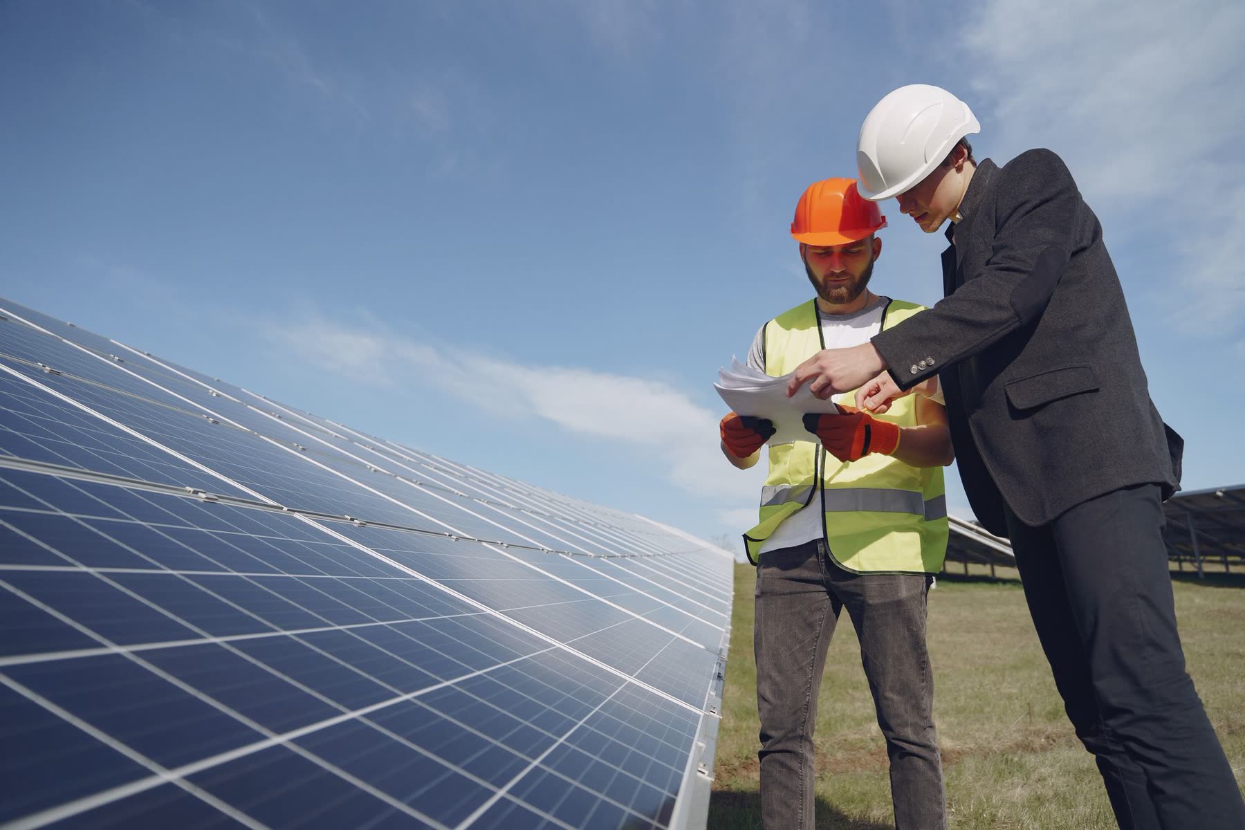 Engineer with a tablet inspecting solar panels on site